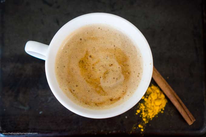 A close up of a turmeric latte in a white mug
