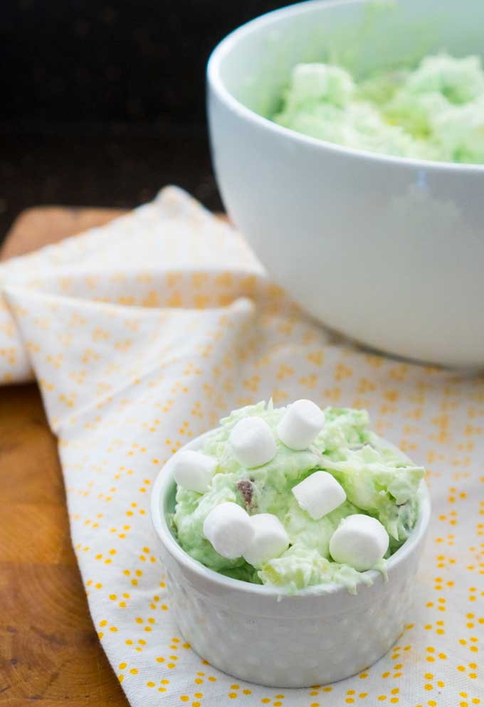 Watergate salad with small marshmallows on a white and yellow kitchen towel