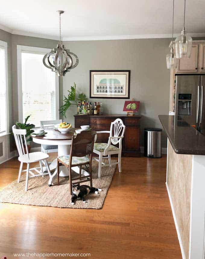 A kitchen with a dining room table and modern light fixture