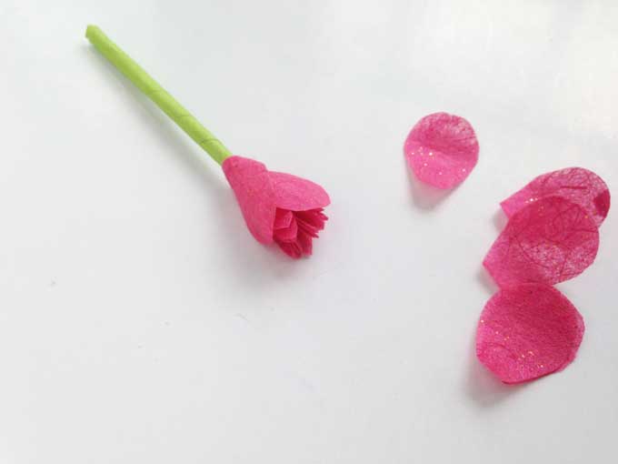 green paper stem with small pink petals glued to the top