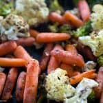 A close up of roasted vegetables including broccoli, cauliflower and carrots