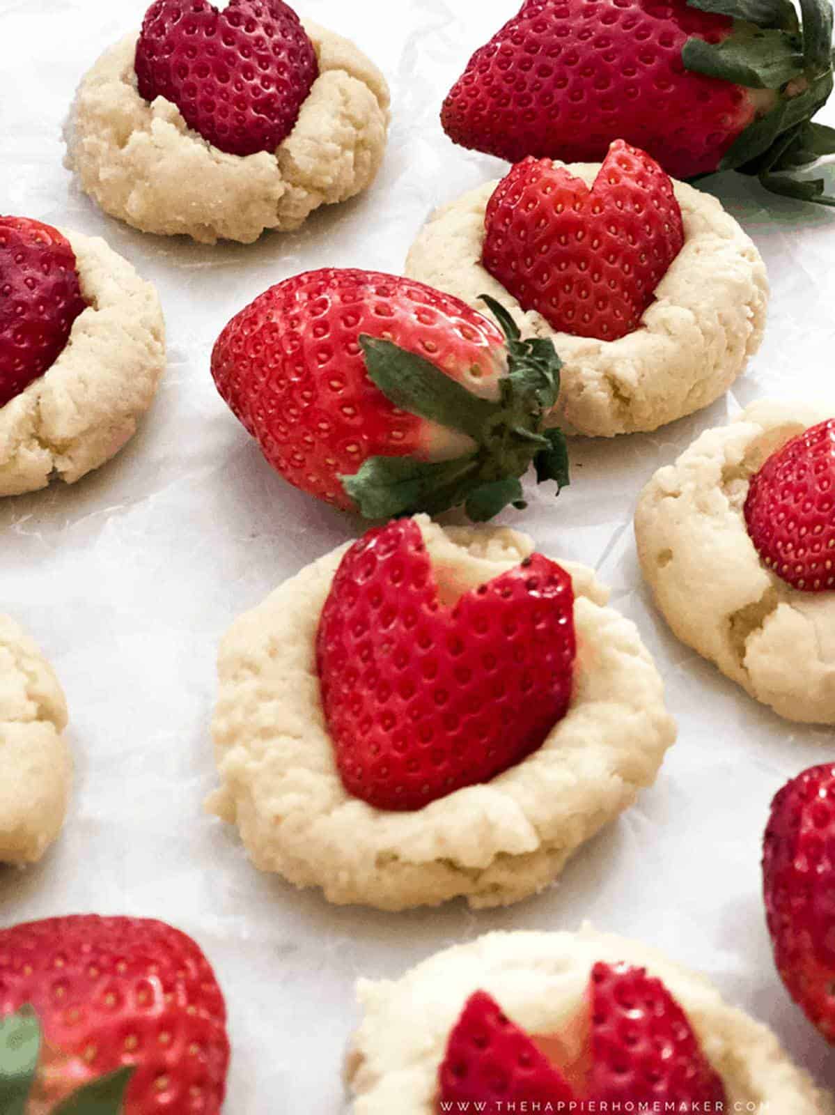 A close up of cookies with heart shaped strawberries on top
