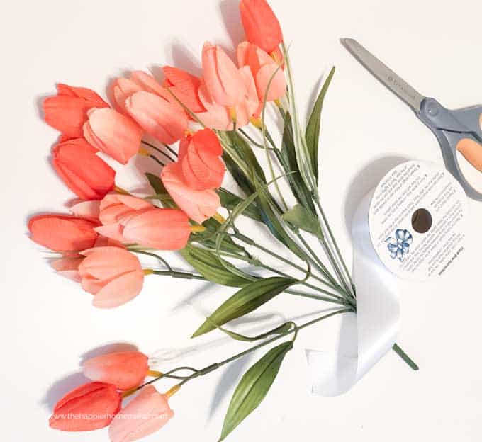 bunch of fake tulips with scissors and white ribbon