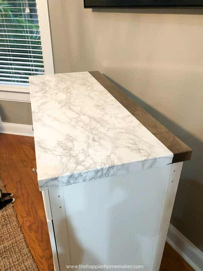 Marble contact paper covering most of the top of a white rolling kitchen island