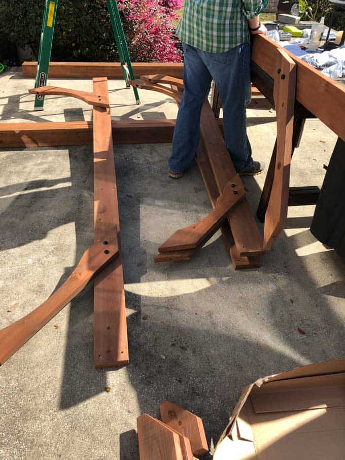 man assembling a pergola on a stone patio