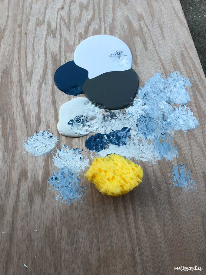 sponging blue and gray paints on piece of wood for food photo backdrop