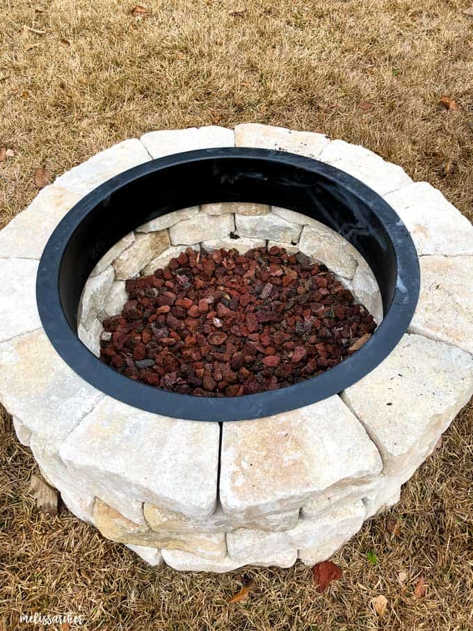 stone fire pit viewed from above with lava rock in the center