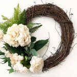 grapevine wreath with fake ferns and white flowers