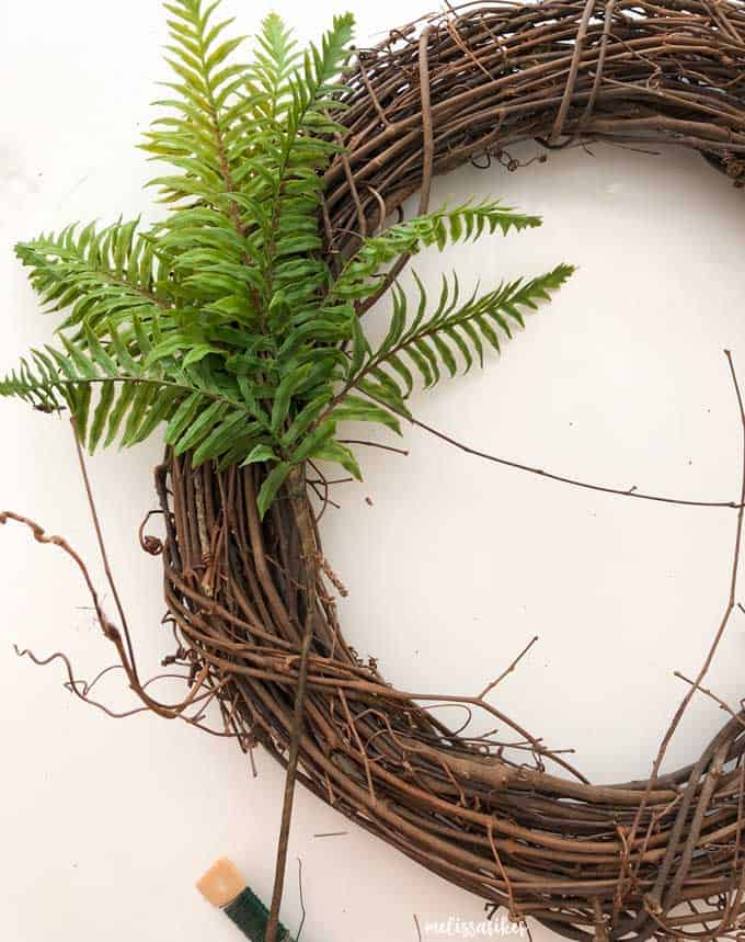 grapevine wreath with fern fronds attached