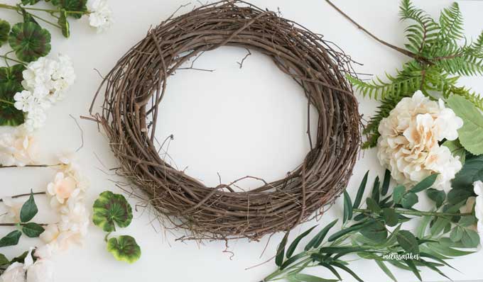 grapevine wreath with faux greenery around it