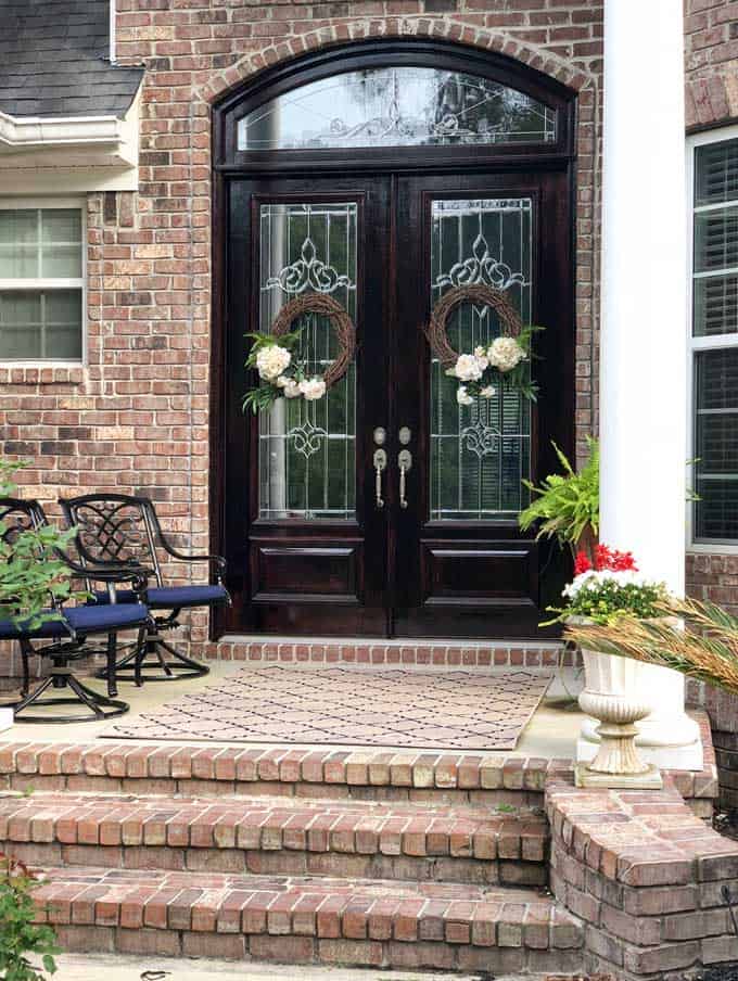 large double wood doors on brick home with matching wreaths