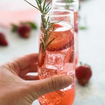 hand holding strawberry sangria in flute