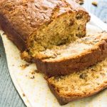 walnut banana bread on cutting board with two slices cut