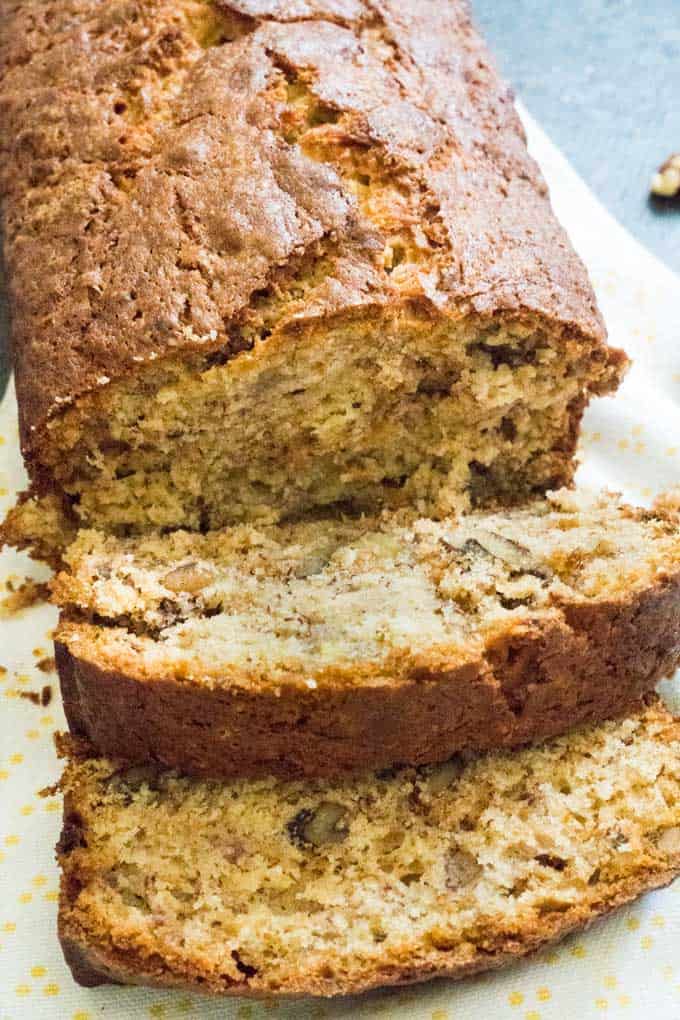 walnut banana bread on cutting board with two slices cut