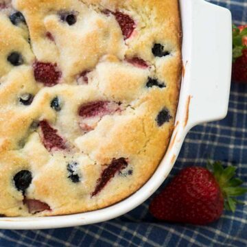 overhead view of berry buttermilk cake in white baking dish