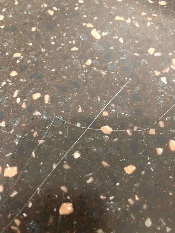 close up of scratched dark corian countertop
