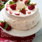 strawberry stuffed angel food cake with shipped cream frosting and strawberries on top