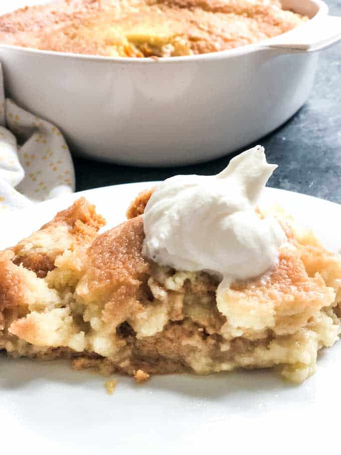 pumpkin dump cake with whipped cream on white plate