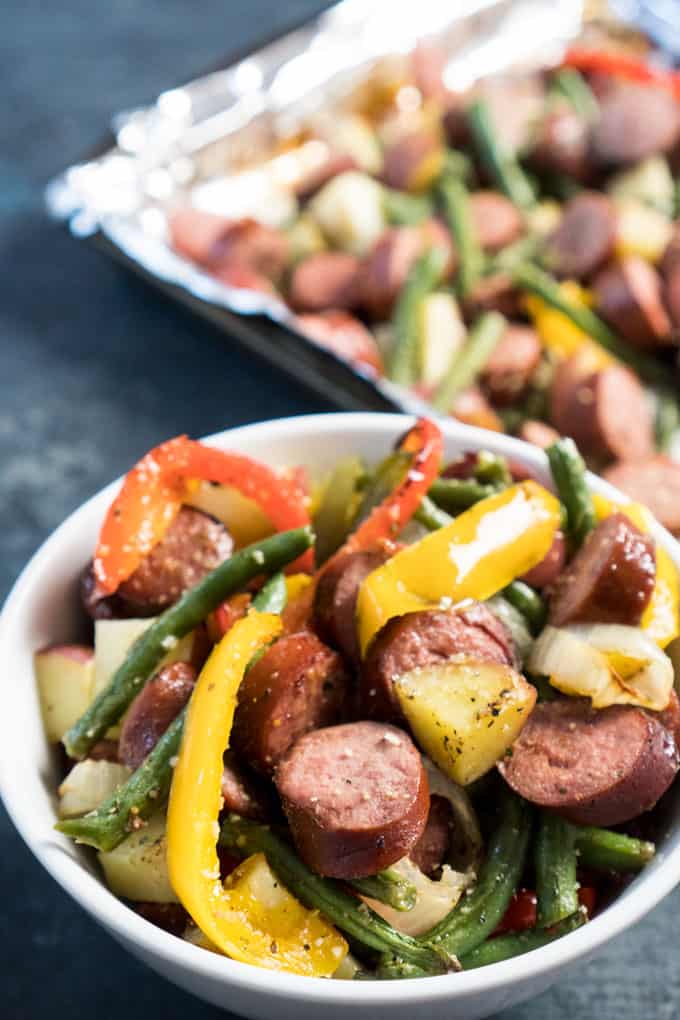 Sheet pan sausage and vegetables in white bowl