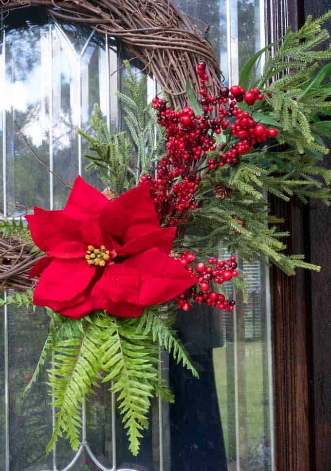 close up of wreath with red flower and greenery