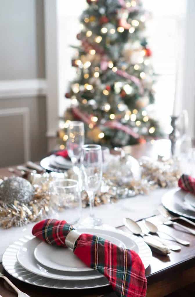 christmas table setting with christmas tree in background