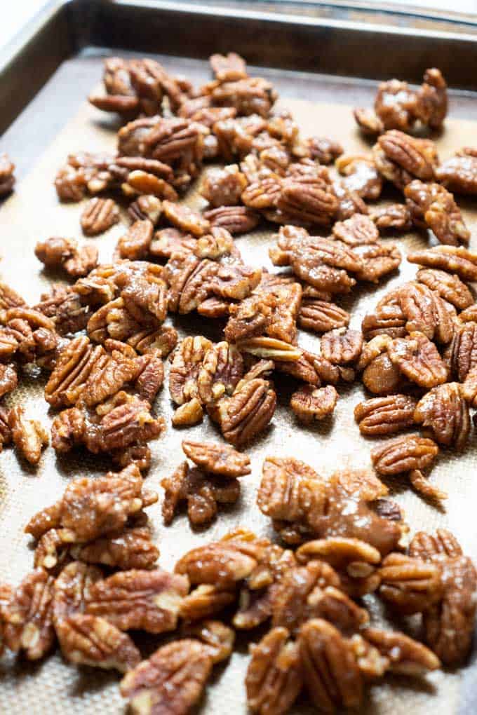 Spicy Candied Pecans on baking sheet with silicone mat