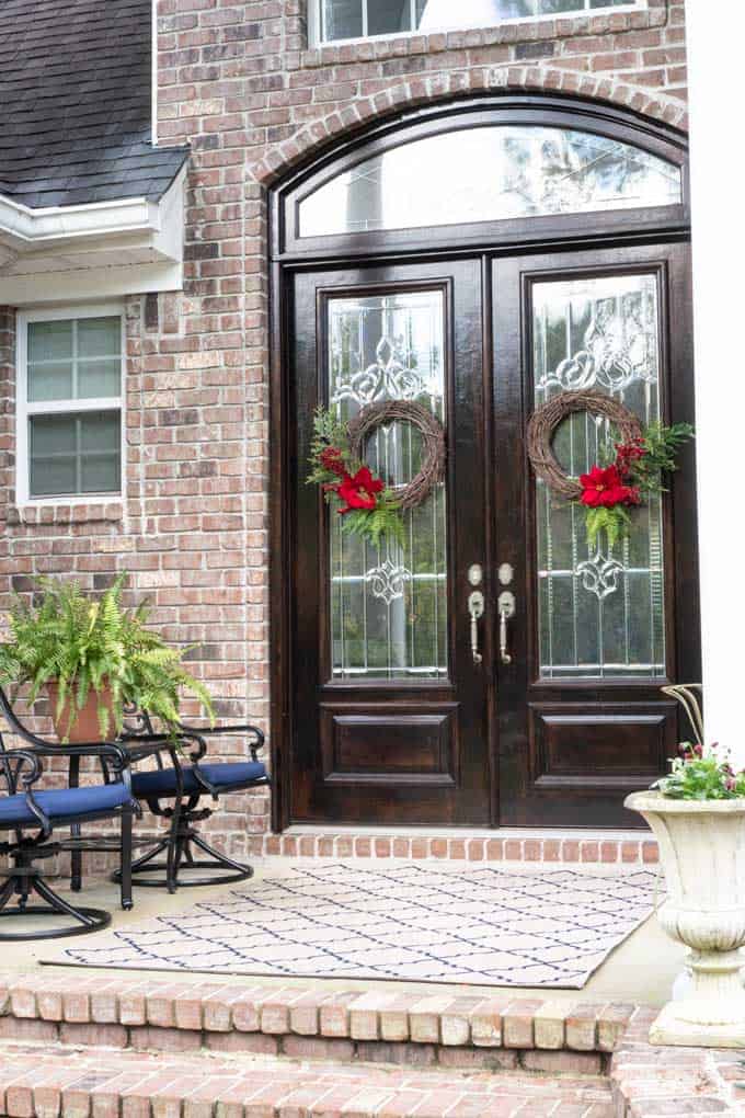 double doors of brick home with christmas wreaths