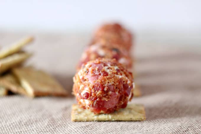 A close up of mini cheeseball on square cracker