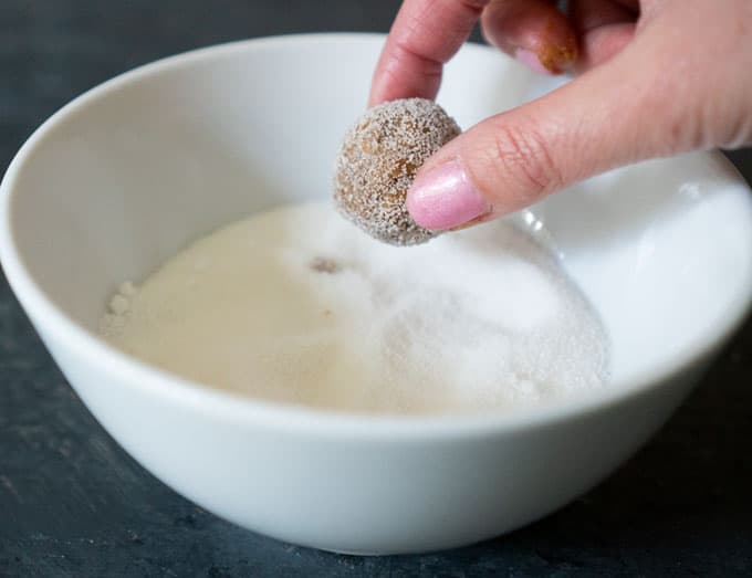 rolling Homemade Gingersnaps ball in sugar before baking