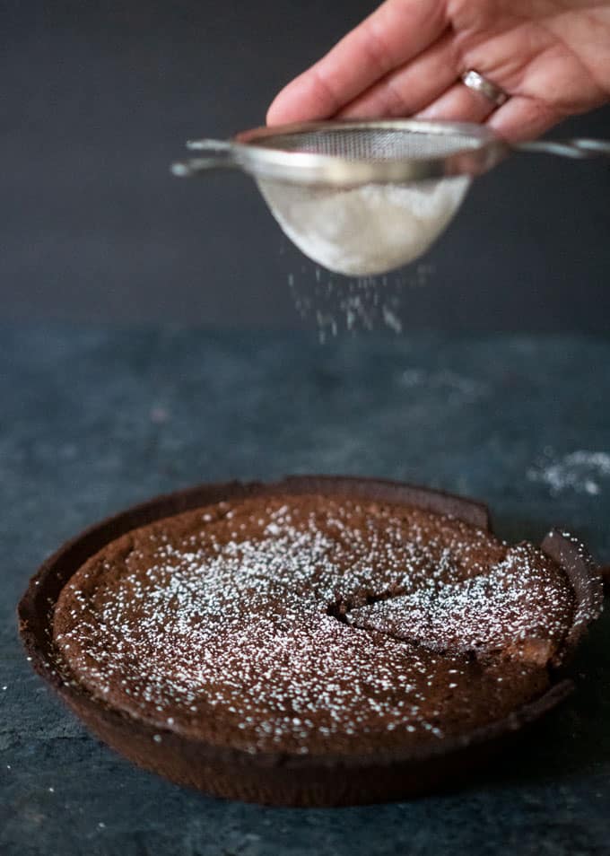 hot fudge pie being dusted with powdered sugar