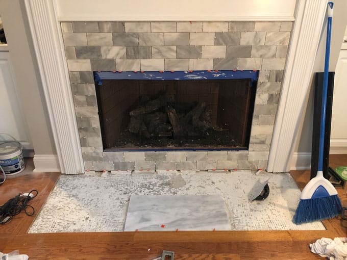 fireplace with marble subway tile surrounding during the tiling process