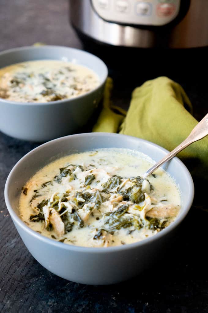 instant pot keto chicken spinach soup in light blue bowls with spoon and green napkin