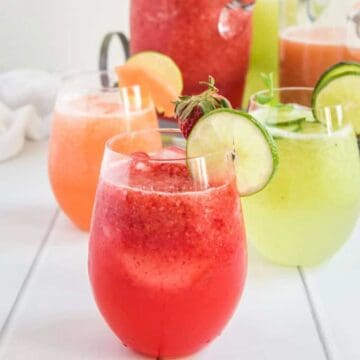 strawberry, cantaloupe and cucumber agua fresca in glasses with pitchers