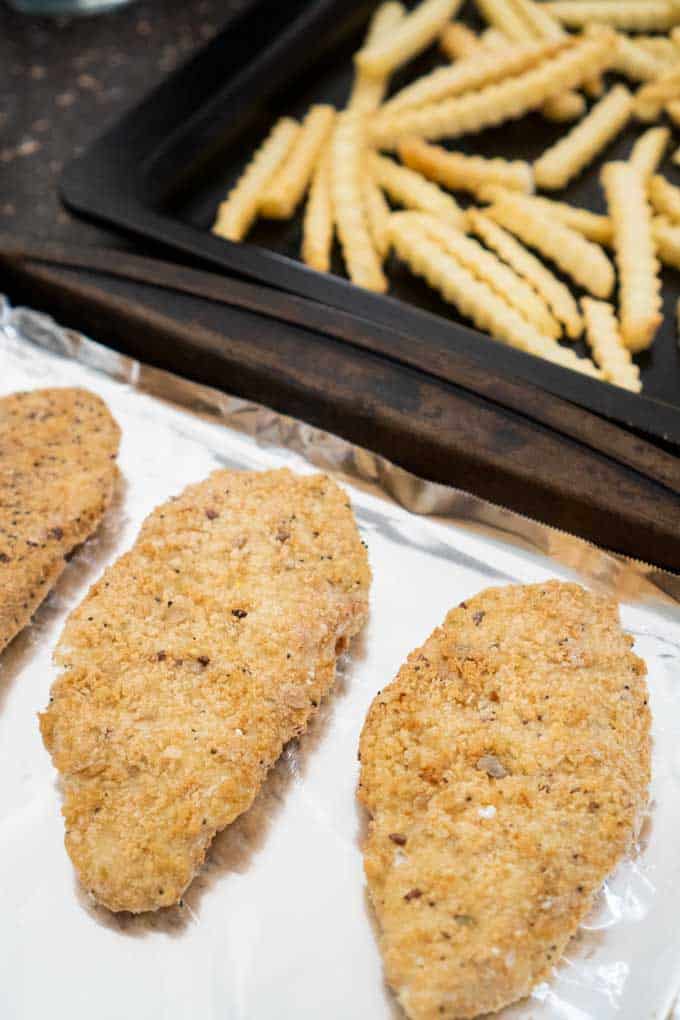 cod fillets and french fries on baking sheet