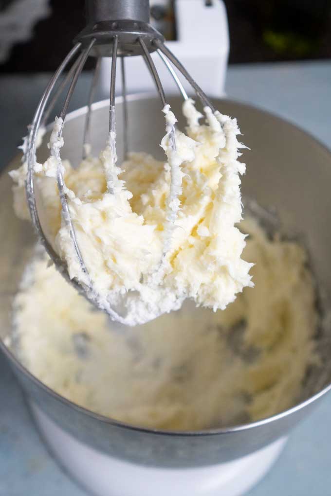 creamed cream cheese and butter on the whisk of a stand mixer