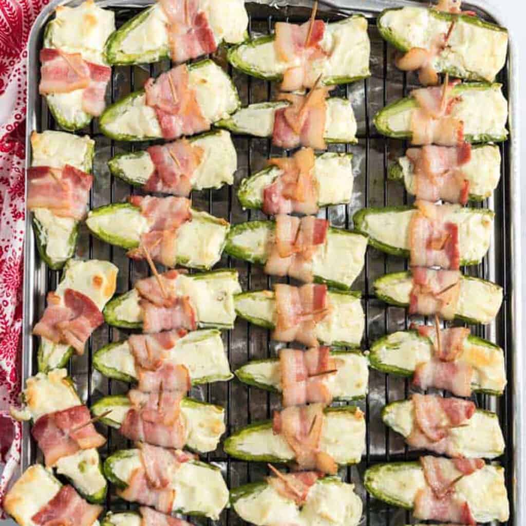 bacon wrapped jalapeño poppers on baking sheet