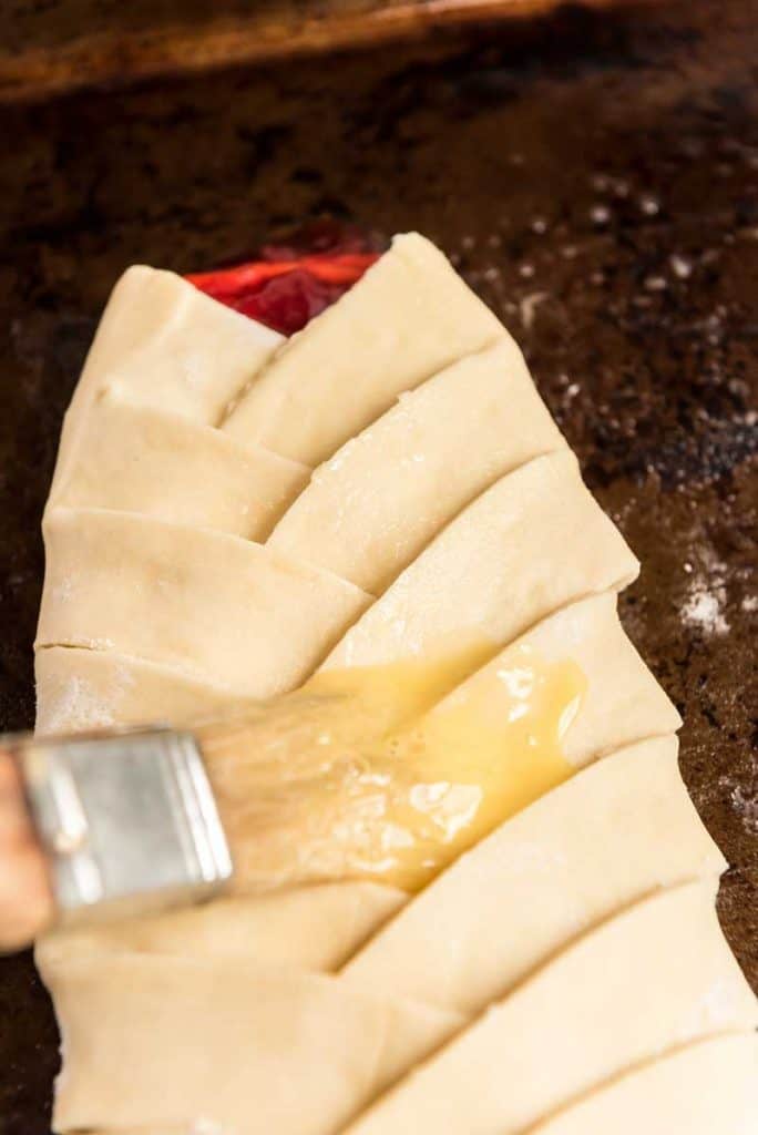 brushing butter over braided cheese danish