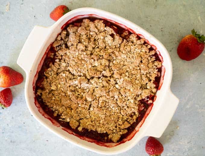 strawberry crisp with oat topping in white casserole dish