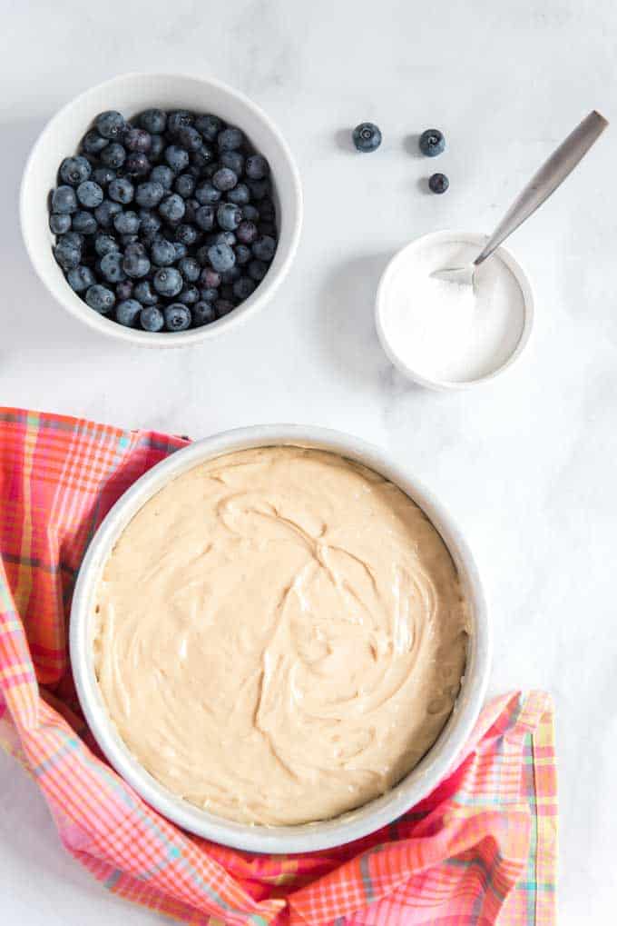white bowl with cake batter small white bowl of blueberries