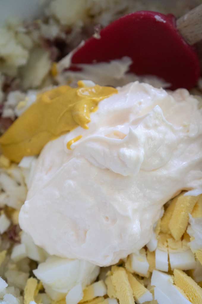 chopped and mashed potatoes with mayonnaise and mustard on top