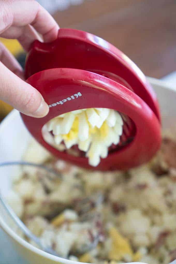 slicing egg into potato salad