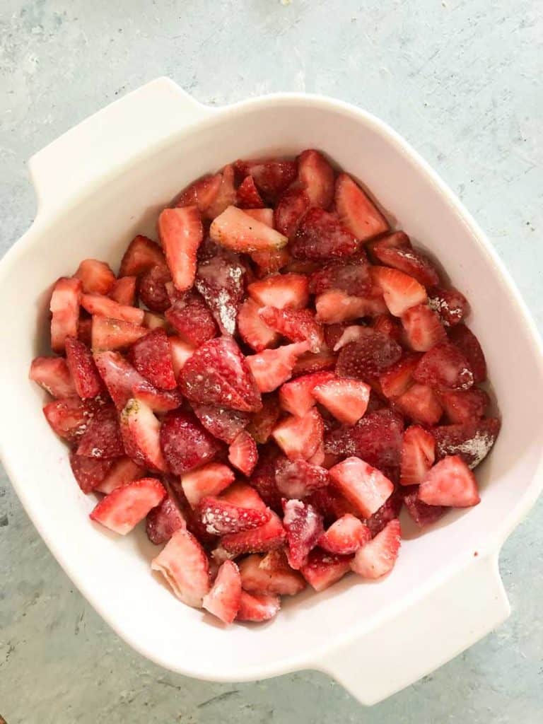 strawberry crisp filling in white casserole dish