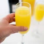 hand holding mimosa in champagne flute
