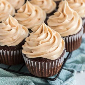 chocolate cupcakes with peanut butter buttercream frosting on blue napkin