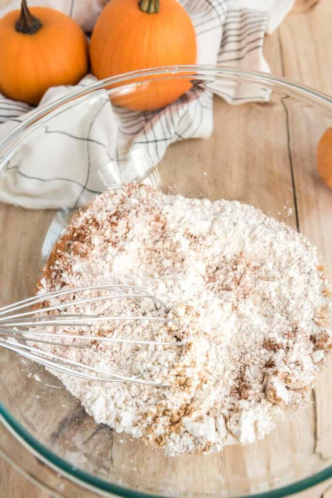 mixing pumpkin pie pancake ingredients in glass bowl