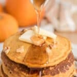 syrup pouring over stack of pumpkin pancakes