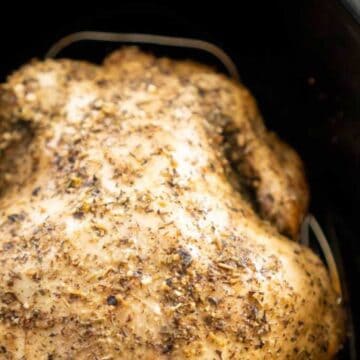 close up of whole chicken in slow cooker