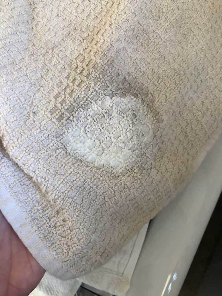 dingy white towel with clean spot after cleaning with homemade stain remover