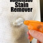 spray bottle spraying homemade stain remover on white towel