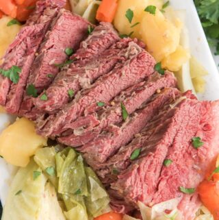 corned beef and cabbage on white platter with carrots and potatoes